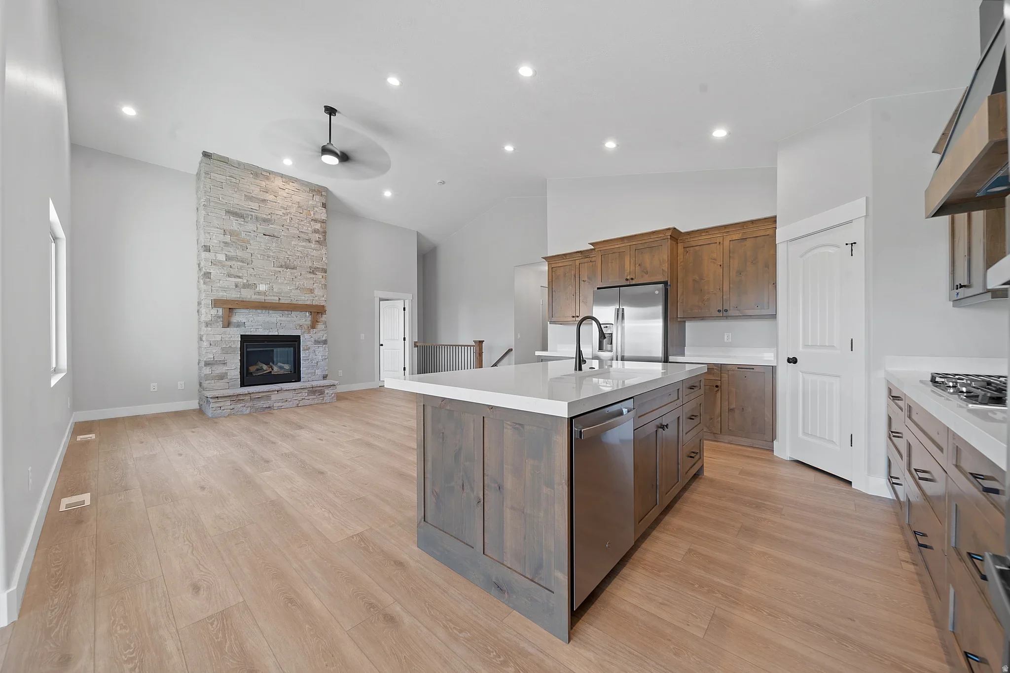 An Eagle Point Homes example with a kitchen island and adjacent stone fireplace