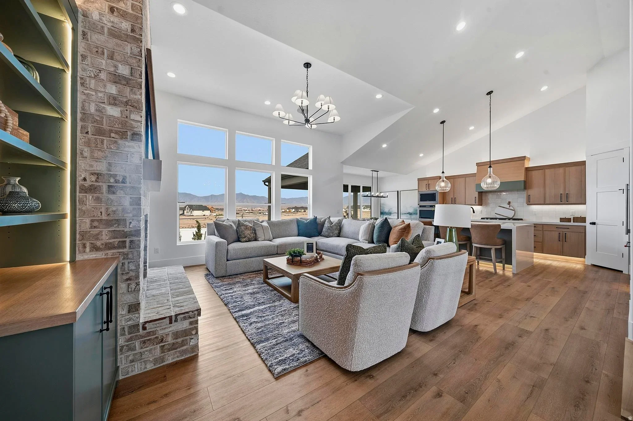 An Eagle Point Homes furnished living area connecting to the kitchen and dining table