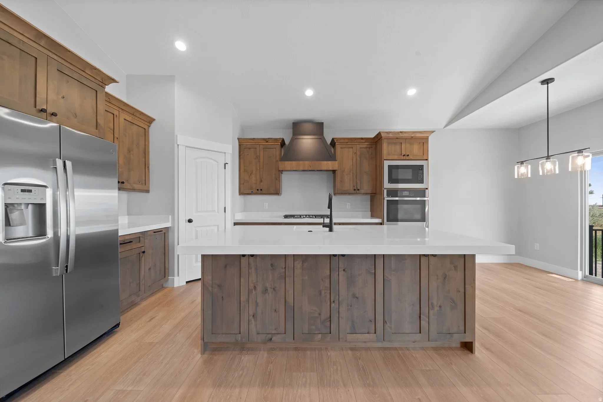 An Eagle Point Homes kitchen with wood cabinets, stone counters, and an island